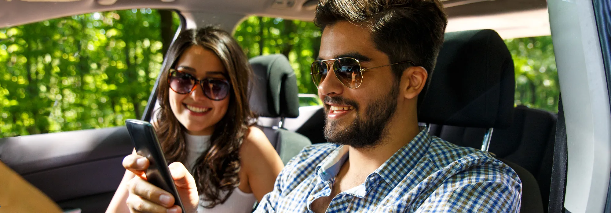 Couple in car driving, passenger on phone